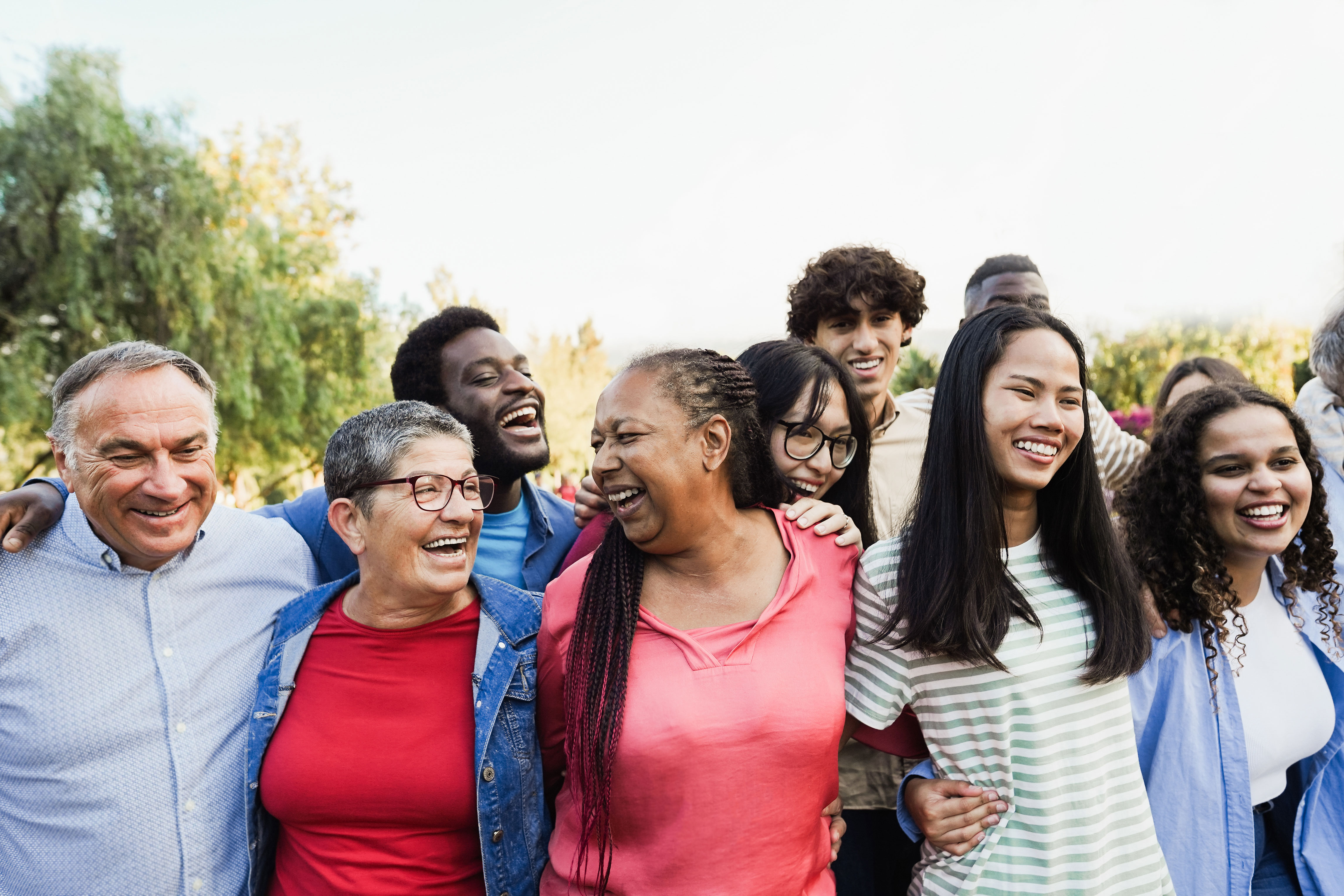 diverse group of people smiling together, outdoors