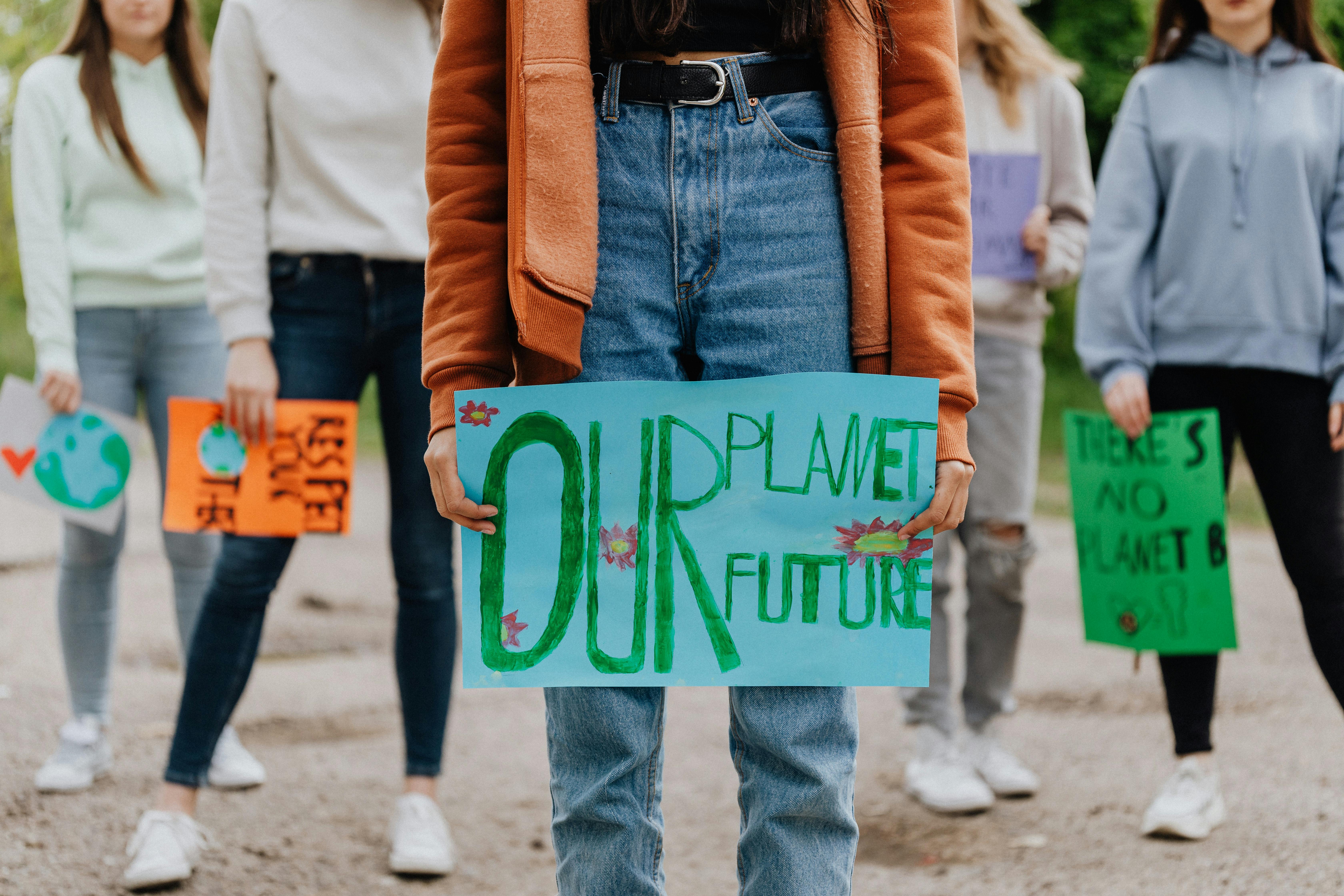 Group of climate activists holding signs. The main one says Our Planet Our Future