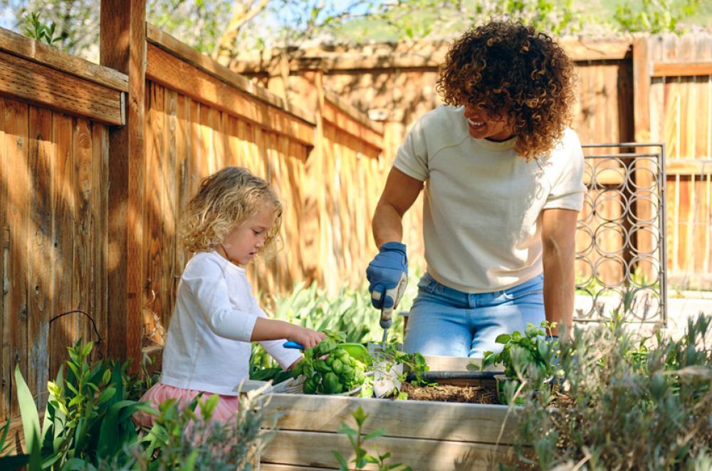 Mother and child tending to a sunny garden plot
