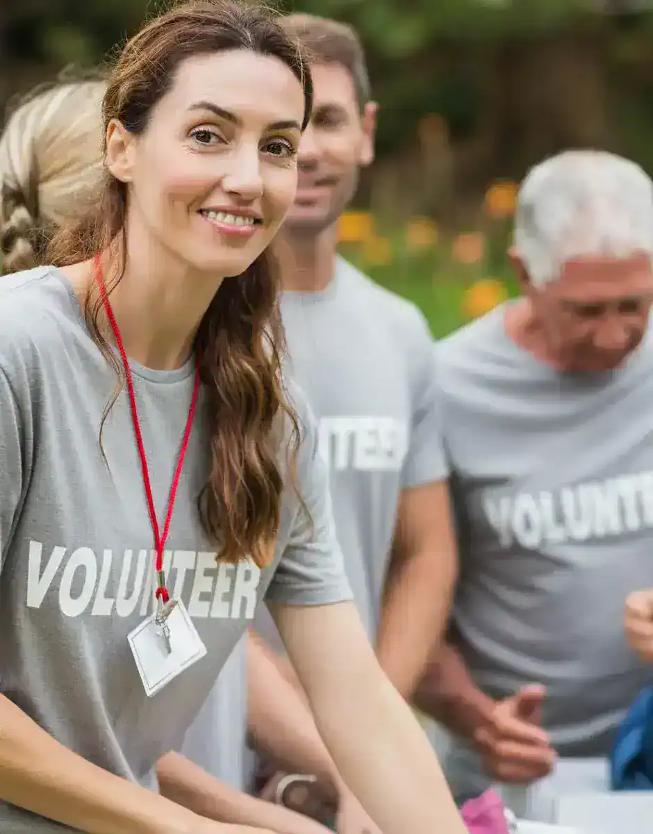 Group of volunteers wearing matching shirts and working together during a community service activity outdoors